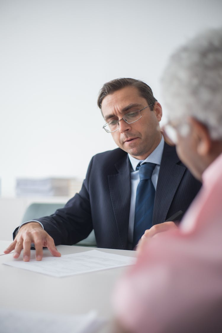 An Insurance Agent Discussing Documents To A Client