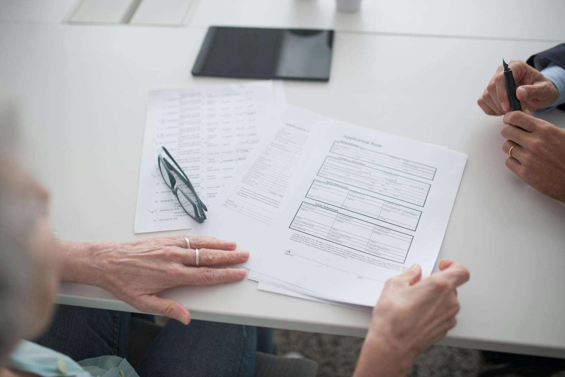 A Person Holding the Documents on the Table