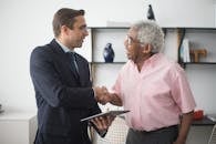 An Insurance Agent and an Elderly Man Shaking Hands