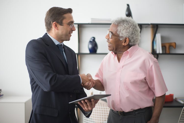 An Insurance Agent And An Elderly Man Shaking Hands