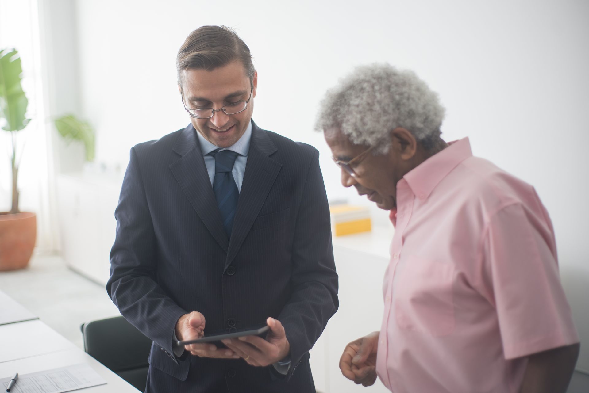 Men Standing Beside Each Other while Looking at the Screen of Tablet Device