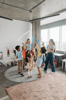 Children enjoying fun activities with teachers in a lively classroom setting.