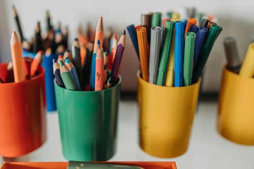 Free Close-up of colorful pencils and pens in bright plastic holders on a desk. Stock Photo