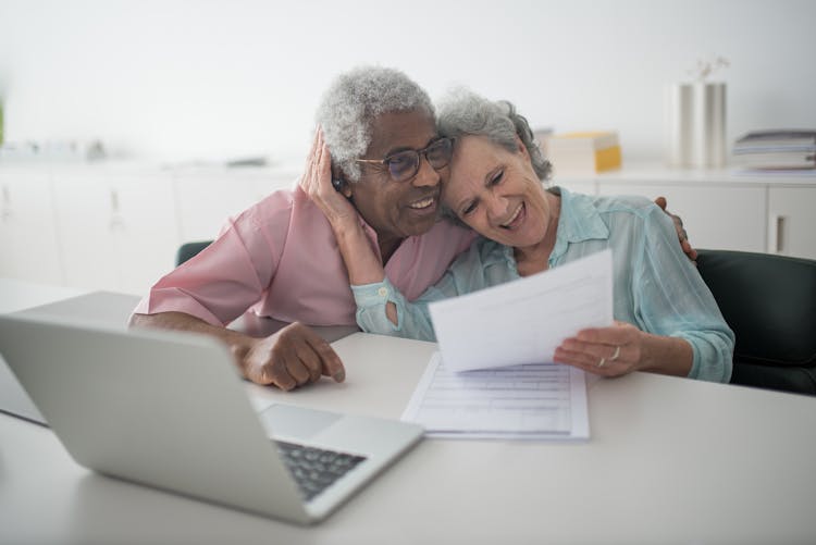 A Happy Elderly Couple Holding A Document