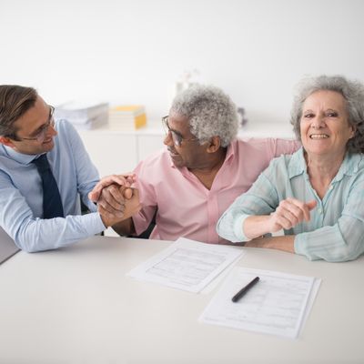 Insurance agent sitting with smiling clients