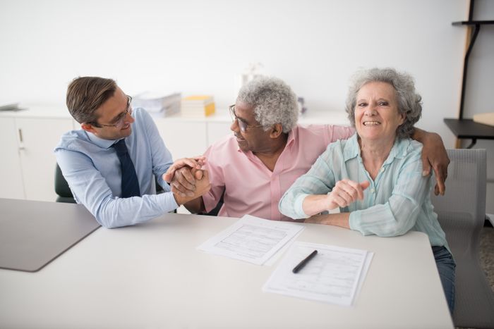 Asesor conversando con clientes que sonríen