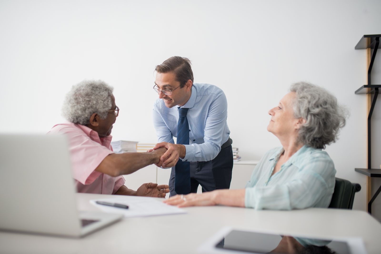 Consulting professional meeting with senior clients in an office