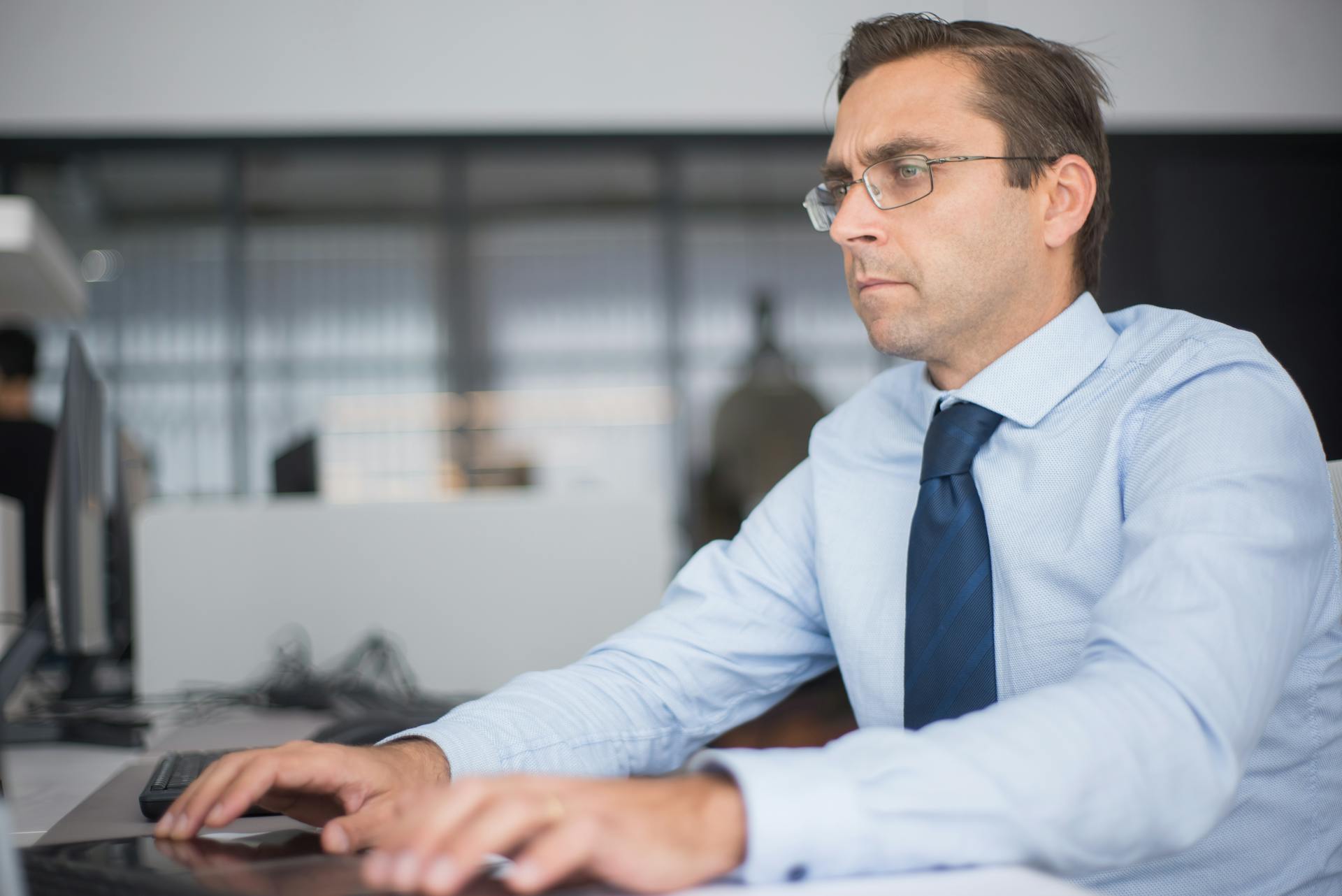 Serious professional man working intensely at computer in office setting.