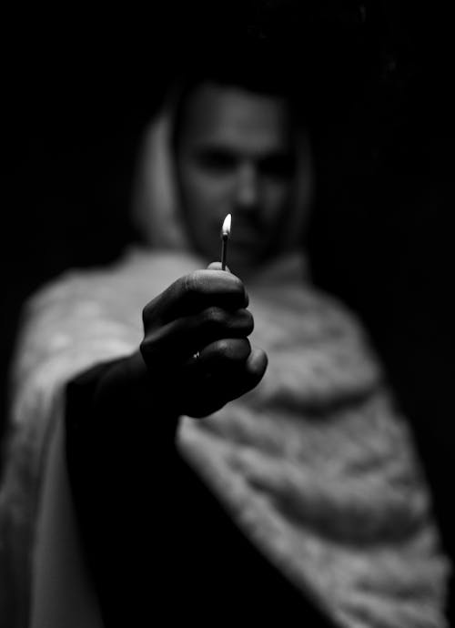 Grayscale Photo of Person Holding Matchstick