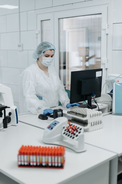 Free Woman in protective gear analyzing data in a laboratory setting. Stock Photo