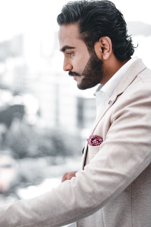 Free Side view portrait of a confident businessman in a suit with facial hair and stylish haircut. Stock Photo