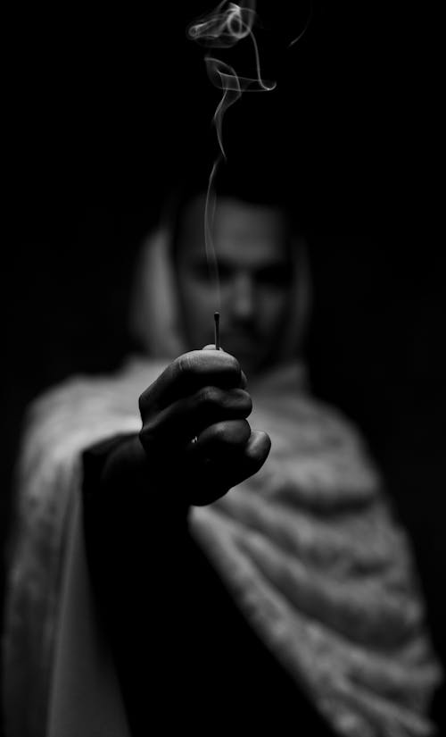 Grayscale Photo of a Person Holding a Matchstick