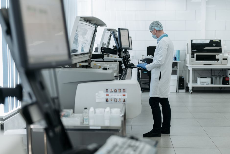 A technician using advanced testing equipment on precious metal samples in a lab A technician using advanced testing equipment on precious metal samples in a lab