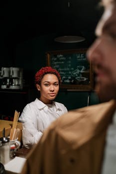 A woman with red hair is captured in a warm, cozy café, creating a friendly and welcoming atmosphere.