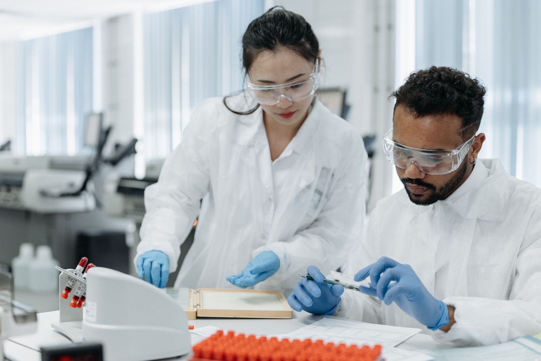 Two scientists working in a laboratory, examining samples with precision and care.
