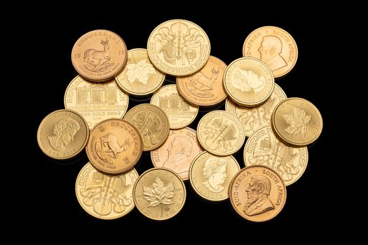 Złoto inwestycyjne – jak zacząć i kiedy sprzedać, aby zarobić? 10 Assorted gold coins showcasing different currencies and designs isolated on a black background.