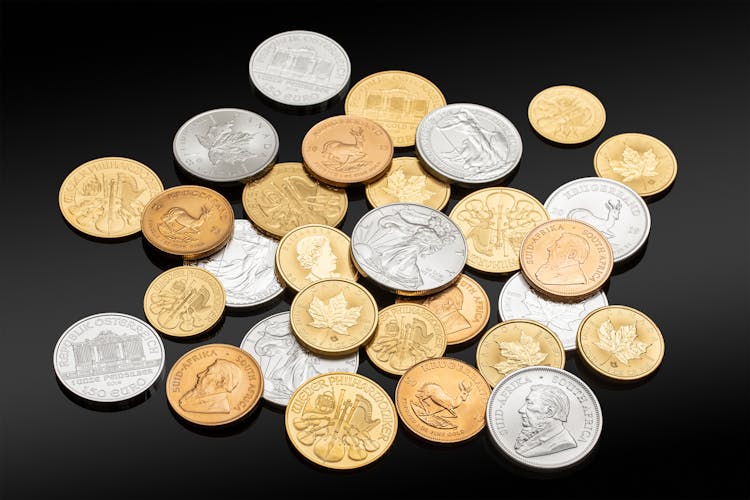 Silver And Gold Coins Over A Black Surface