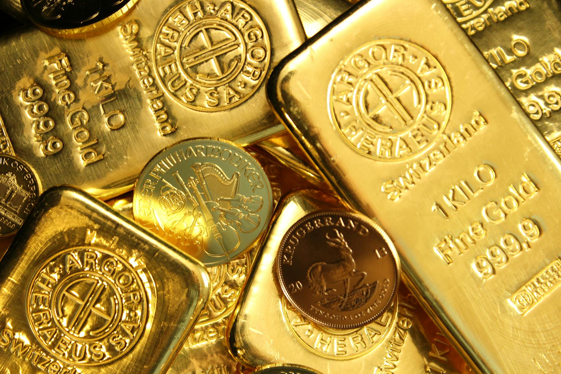 Close-up of shiny gold bars and coins, representing wealth and fortune.