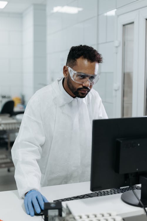 Free A Man in Lab Gown Working on the Lab Computer Stock Photo
