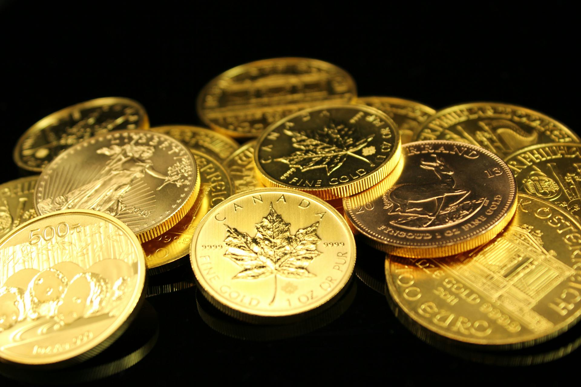 A collection of gold coins showcasing wealth and prosperity on a black background.