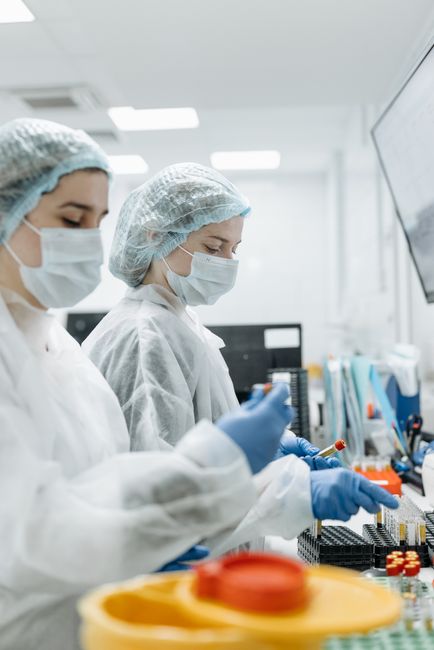 Two scientists in PPE conducting experiments in a modern laboratory.