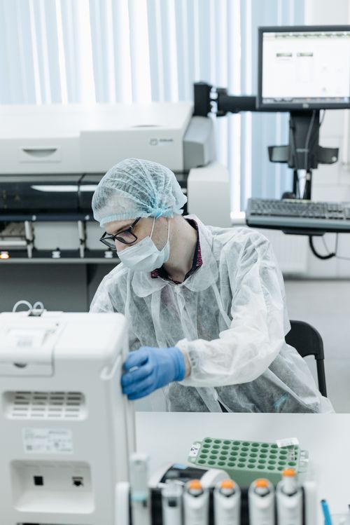 Free Scientist in protective gear operating equipment in a modern laboratory. Stock Photo