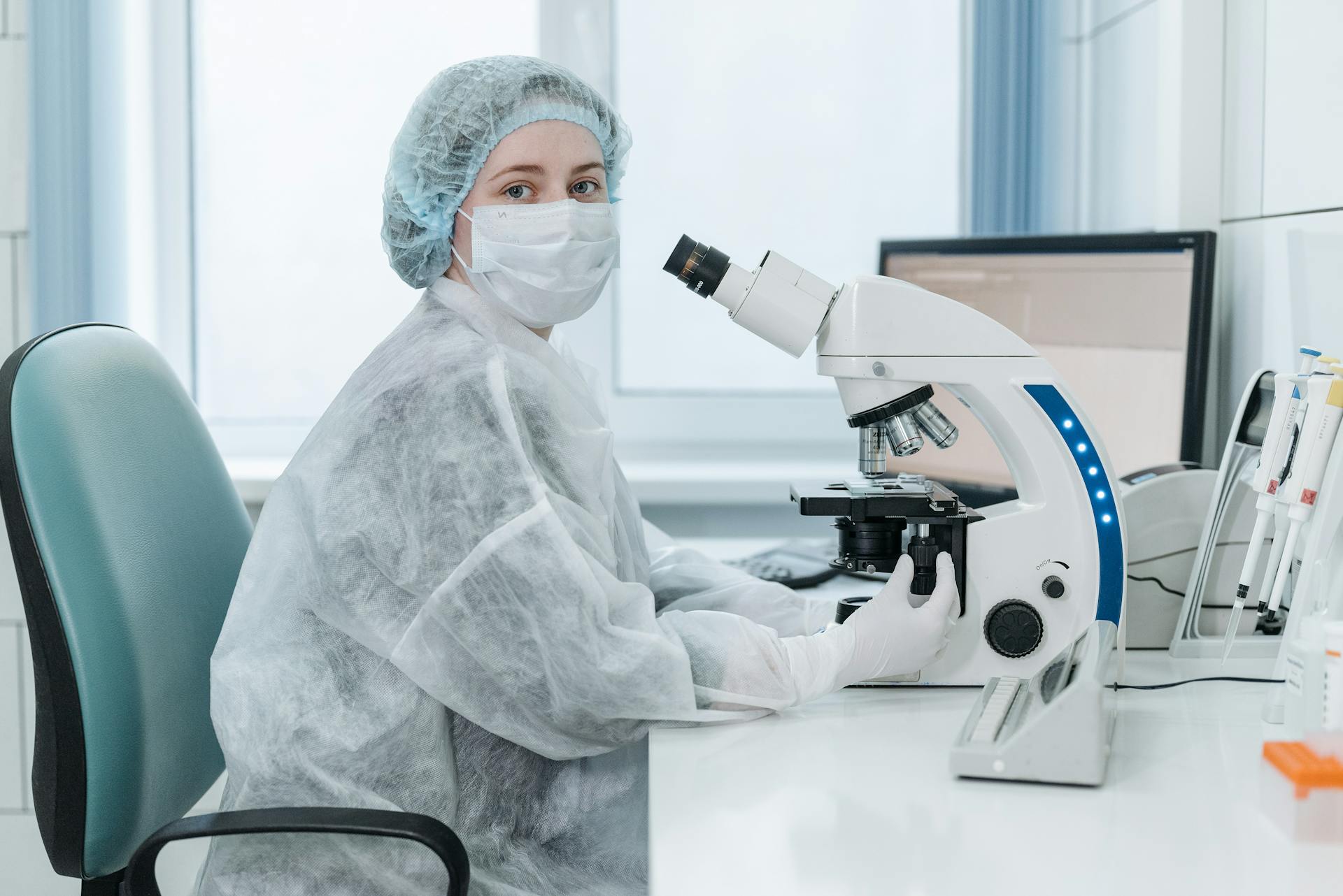 Woman Doctor Next to a Trinocular Microscope