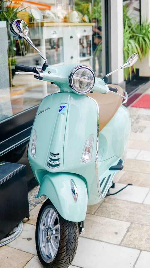 Free Elegant aqua scooter with chrome accents parked on a sunny day. Stylish urban transportation. Stock Photo