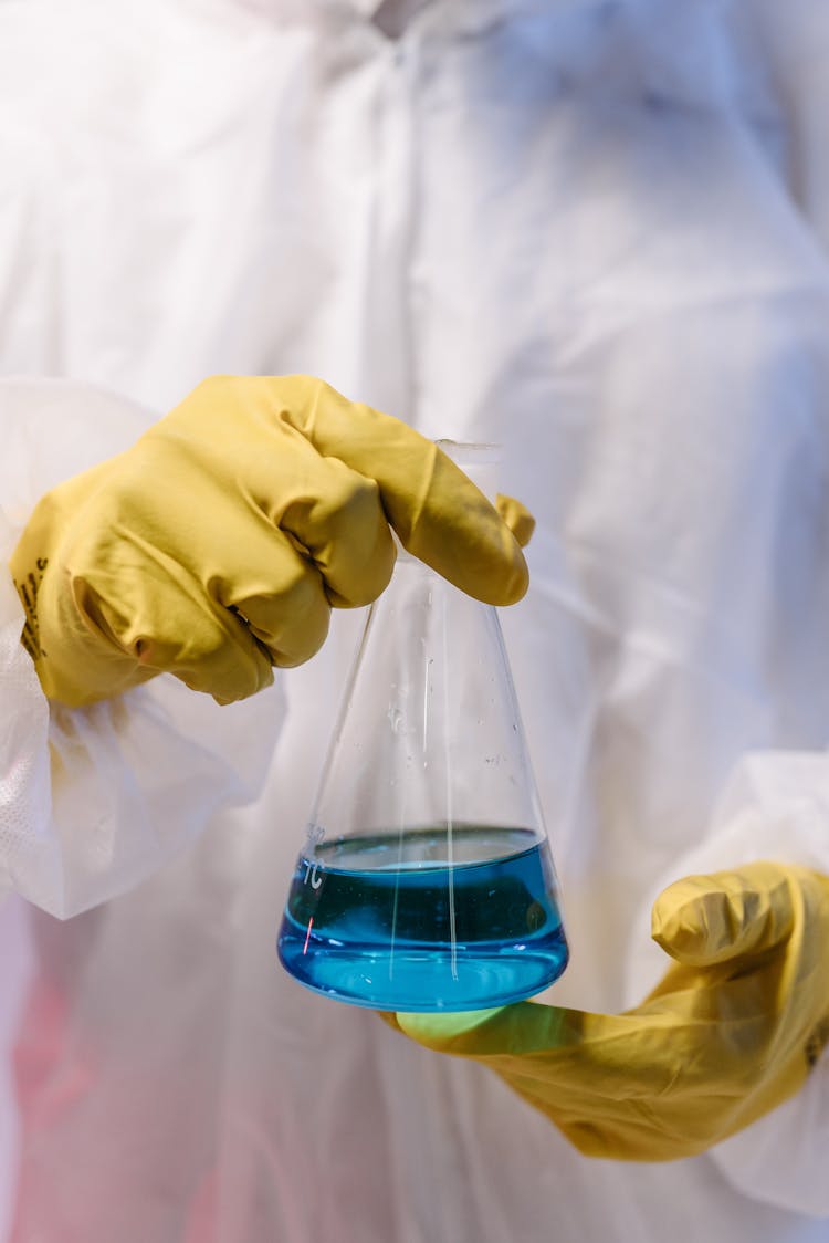 A Person Holding A Flash With Colored Liquid