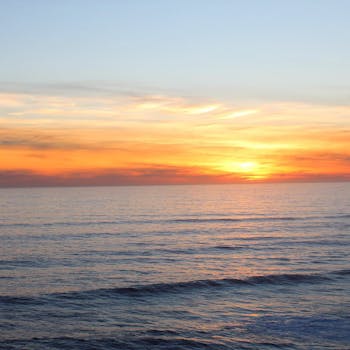 A serene ocean view at sunset with vivid colors illuminating the sky.