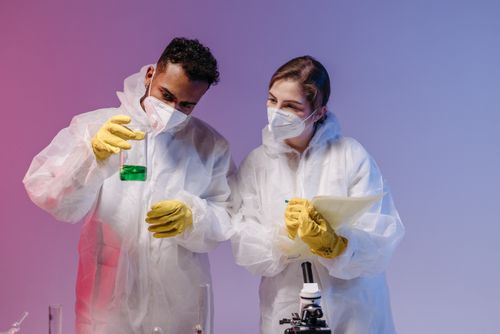 Free Two scientists in protective gear conducting experiments in a laboratory. Stock Photo