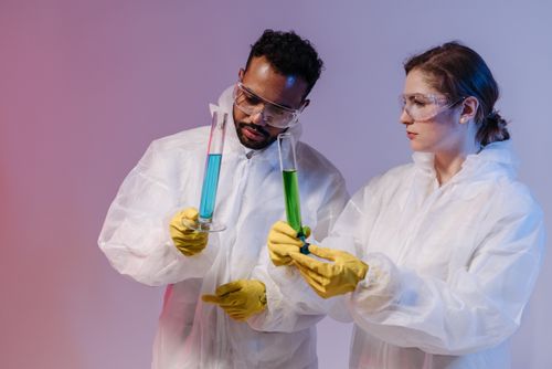 Free Two scientists in protective gear analyze chemical samples in a laboratory setting. Stock Photo