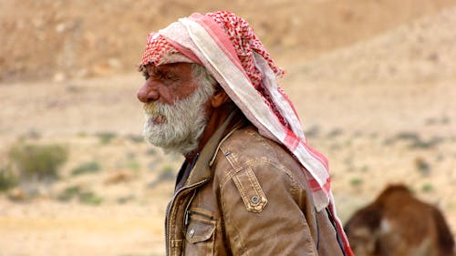 An Elderly Man in Brown Jacket Wearing a Headscarf