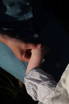 A heartwarming close-up of a child's hand being held by a parent, symbolizing care and love.