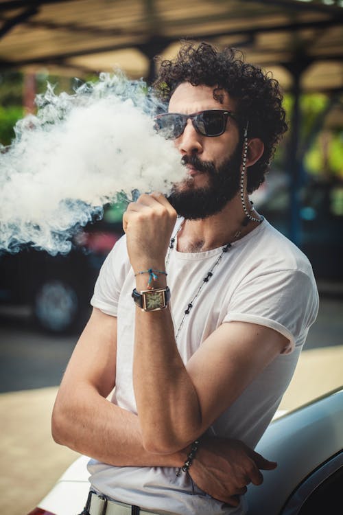 Man in White Crew Neck T-shirt Smoking Vape