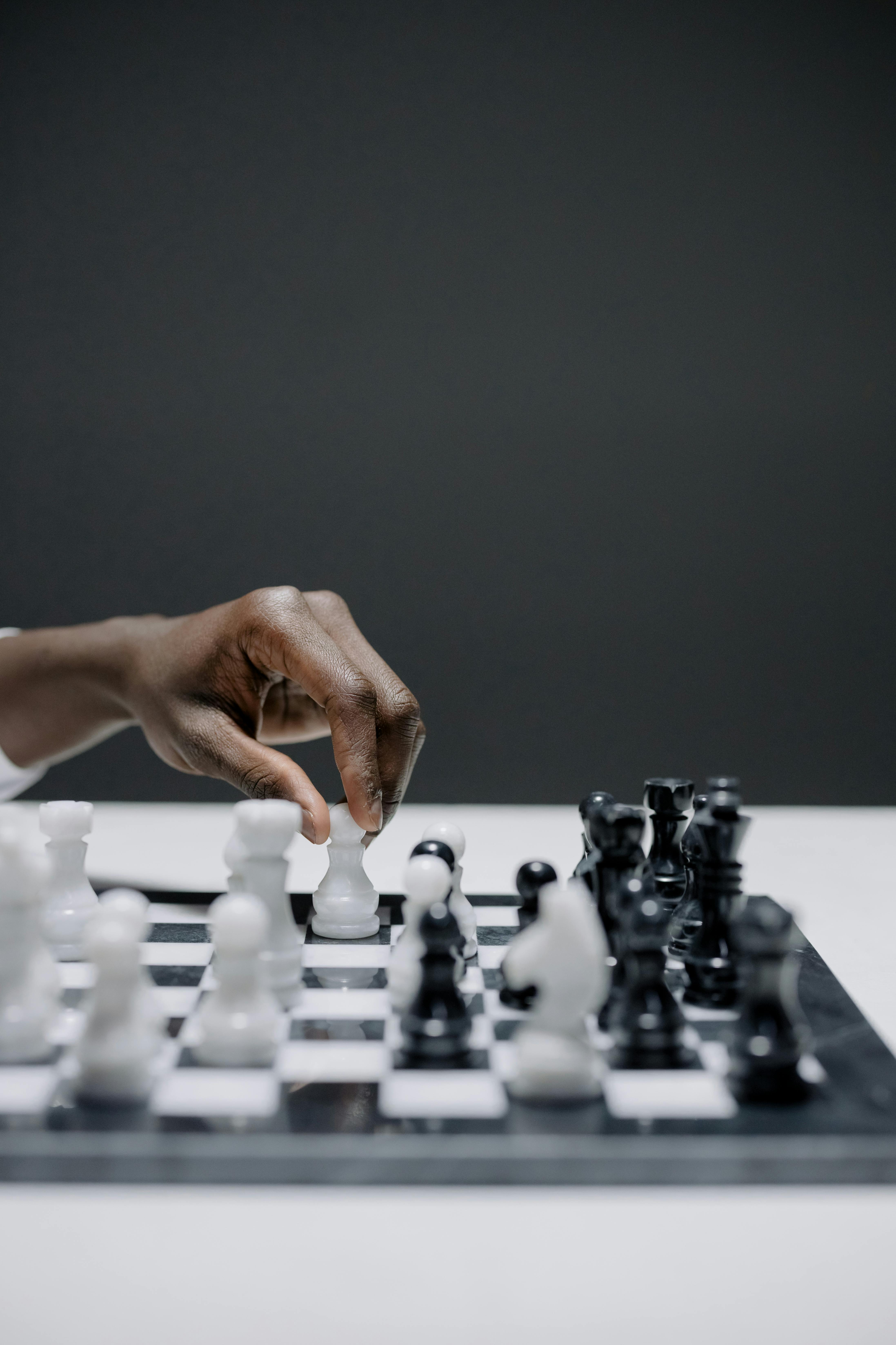 Download A Person Is Playing Chess On A Board Wallpaper