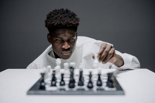 Man in White Long Sleeve Shirt Playing Chess