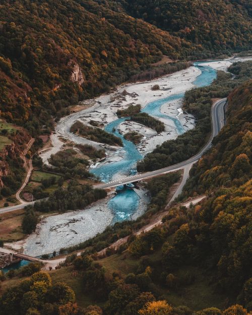 Free Captivating aerial view of the Teberda River winding through lush green mountains. Stock Photo