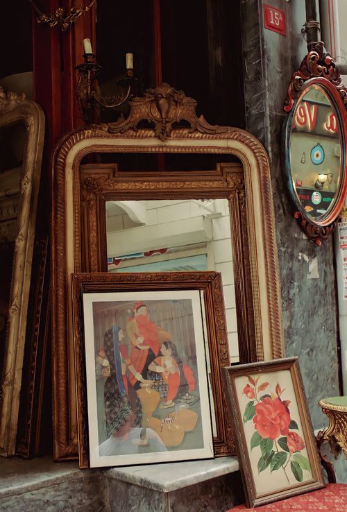 Free A collection of vintage mirrors and framed artwork displayed in an antique store setting. Stock Photo