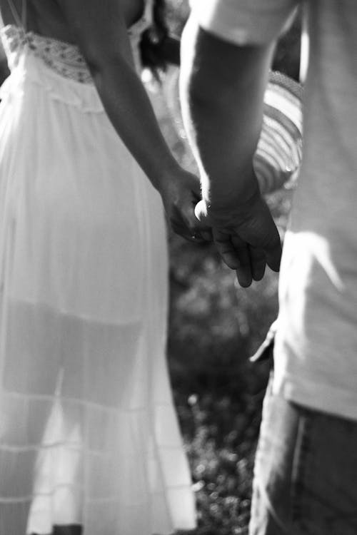 A Couple Holding Hands on Their Wedding Day
