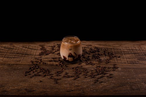  Glass of Iced Coffee on Brown Surface with Scattered Coffee Beans