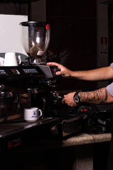 Barista expertly preparing coffee using an espresso machine in a cafe setting.