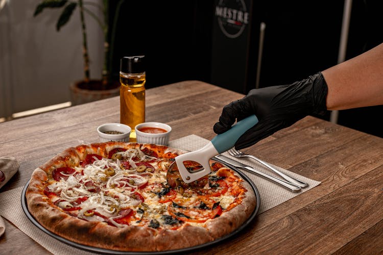 Person Slicing A Pizza