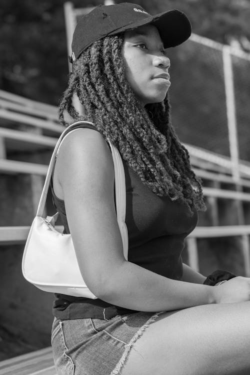 Grayscale Photo of Woman in Tank Top Carrying a Shoulder Bag