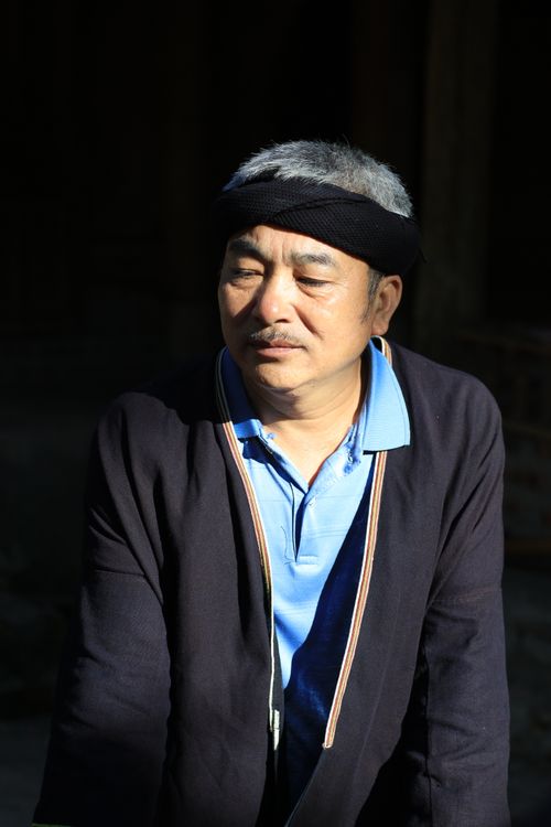 Free A thoughtful middle-aged man in traditional attire standing outdoors in bright daylight. Stock Photo