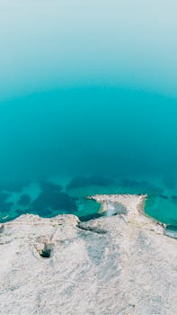 Stunning aerial shot of Krk's coastline with clear turquoise waters and rocky formations.