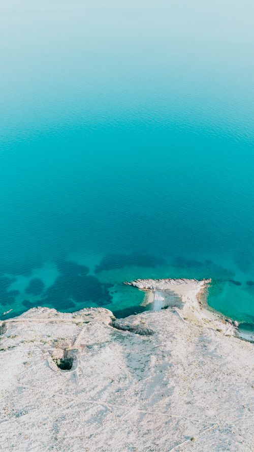 Free Stunning aerial shot of Krk's coastline with clear turquoise waters and rocky formations. Stock Photo