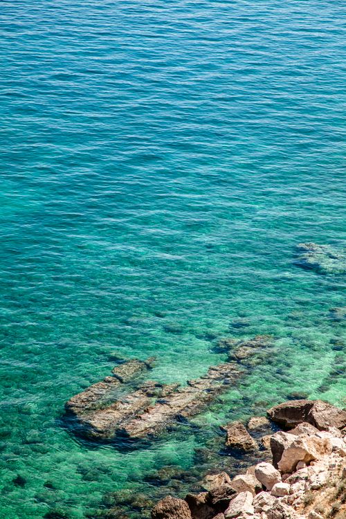 Free A mesmerizing aerial shot of the clear turquoise waters and rocky coastline of Krk, Croatia. Stock Photo