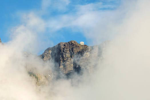 A scenic view of rocky cliffs surrounded by mist in Leukerbad, Switzerland.