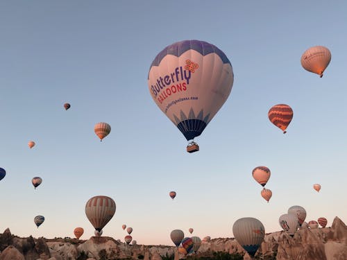 Free Hot Air Balloons Flying over Brown Mountain Stock Photo